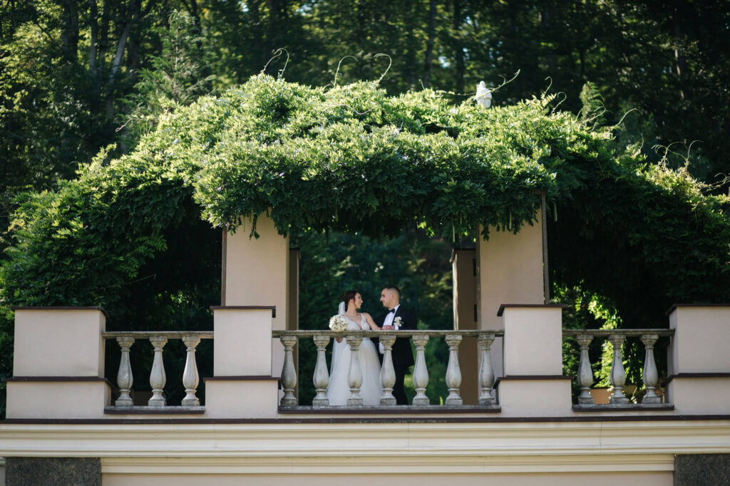 Newly-wed couple taking photo-shoot in our classical-style venue balcony with lush green foliage